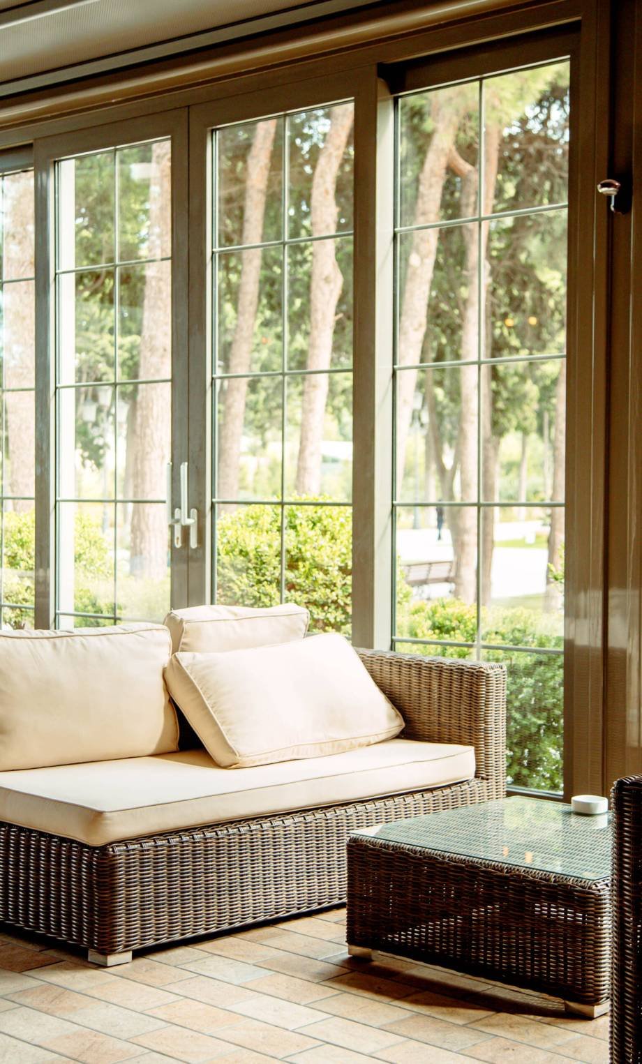 outdoor sofa with beige cushions and coffee table in front of the restaurant window